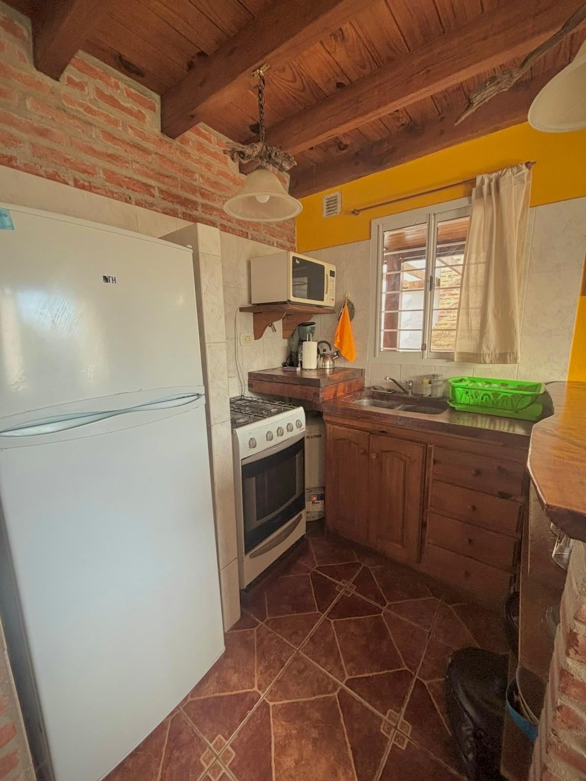 Cocina equipada con heladera, horno y microondas