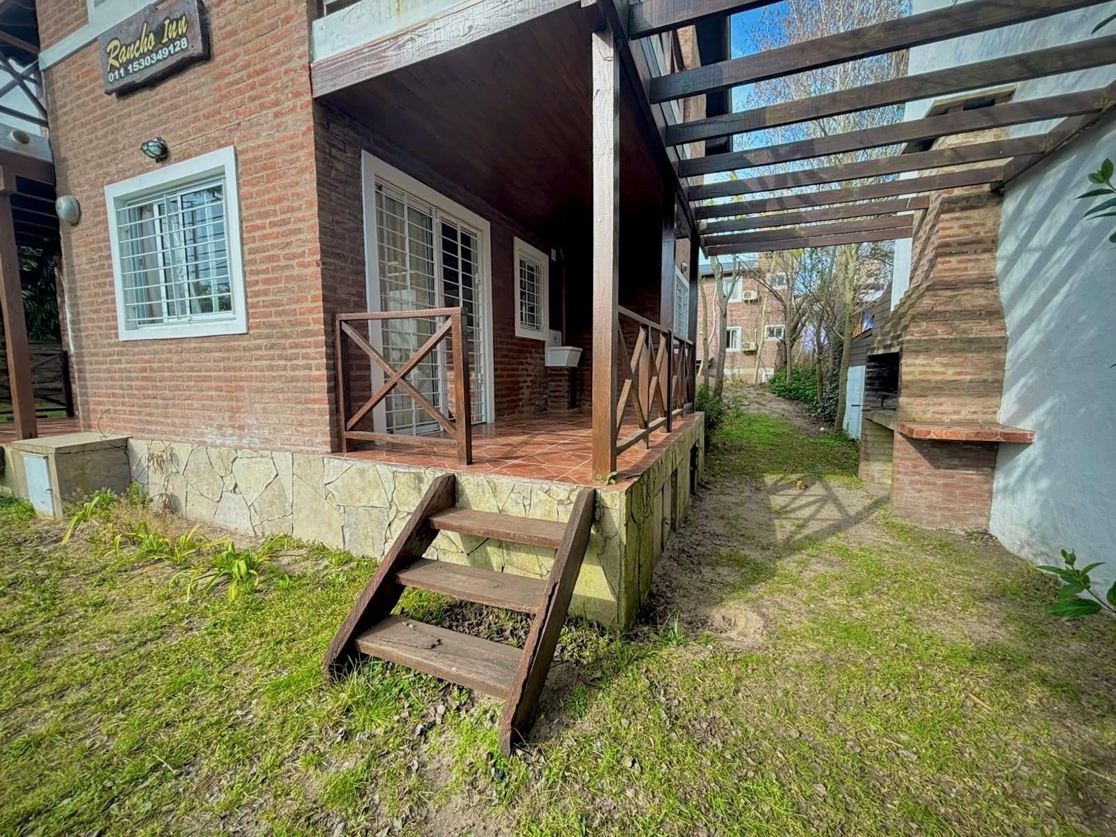 Galería exterior con parrilla de ladrillo y pérgola