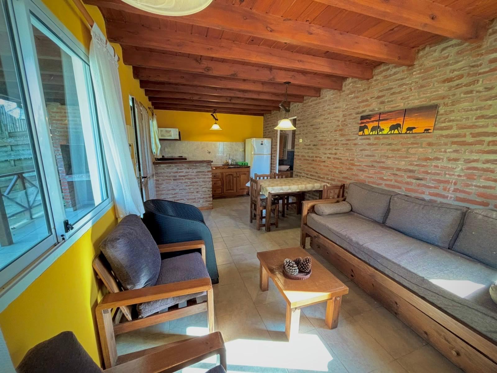 Living luminoso con paredes de ladrillo y techo de madera