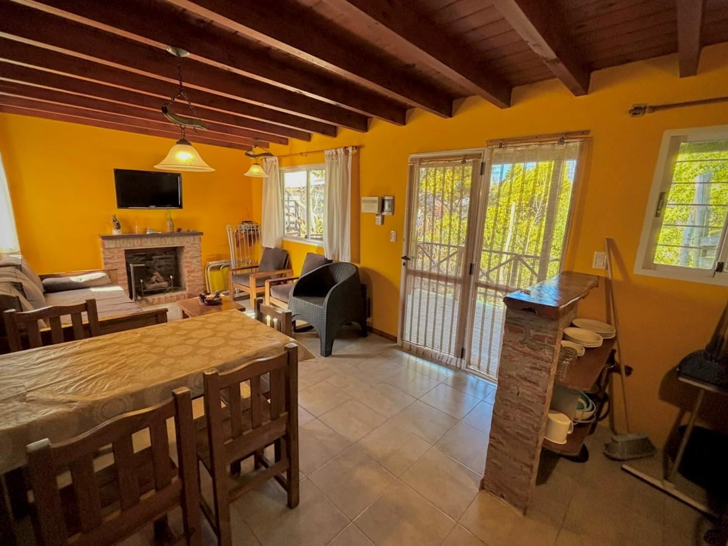 Living comedor con hogar a leña y salida al balcón