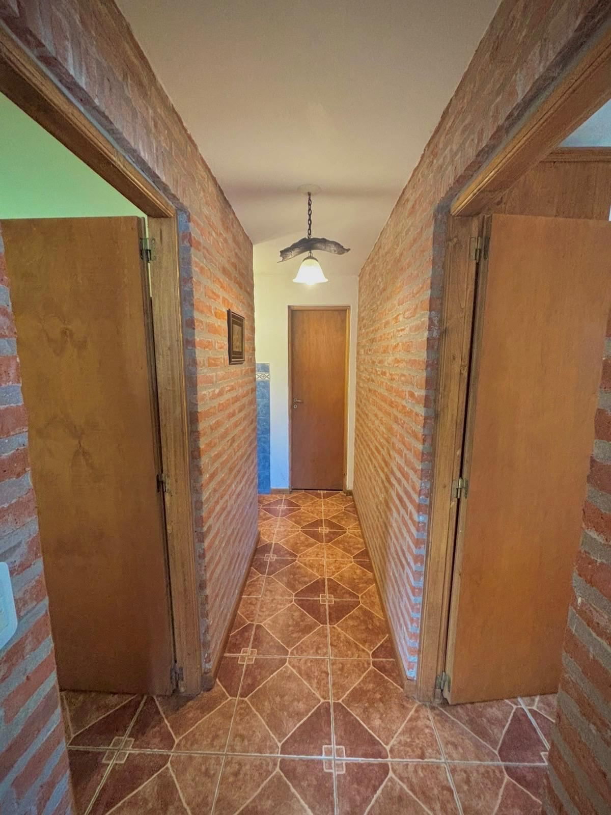 Pasillo de ladrillo hacia los dormitorios